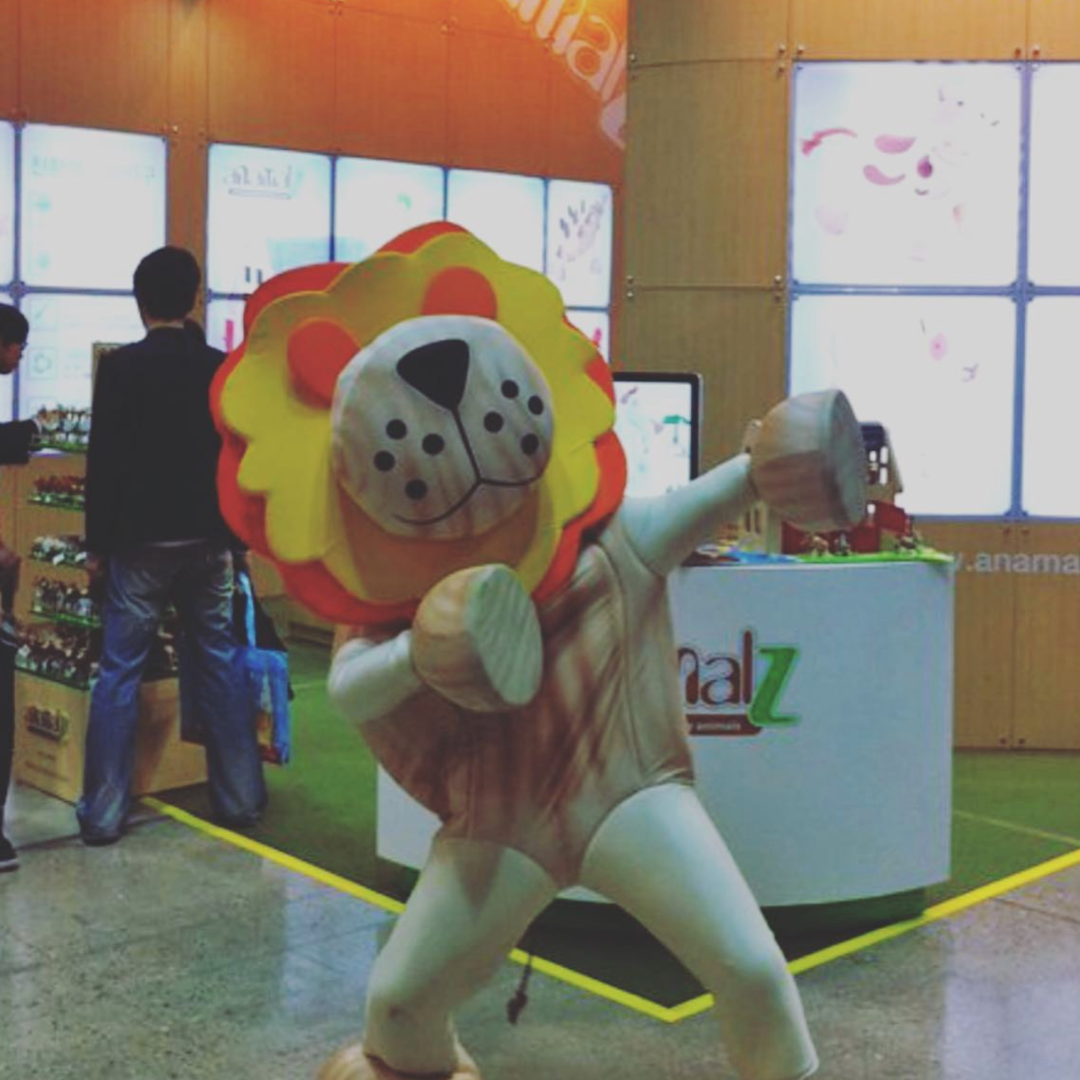 man in lion suit posing in front of a stand