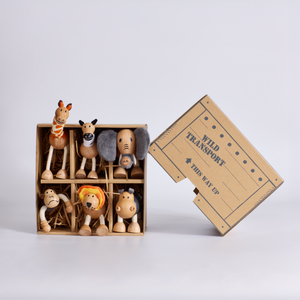 Set of wooden animal figurines in a box with 'Wild Transport' label on a white background