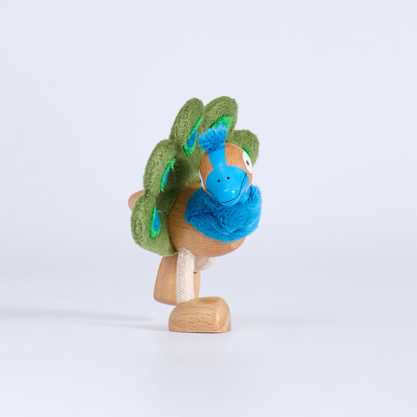 Small figurine with a blue bird and green tree on a white background