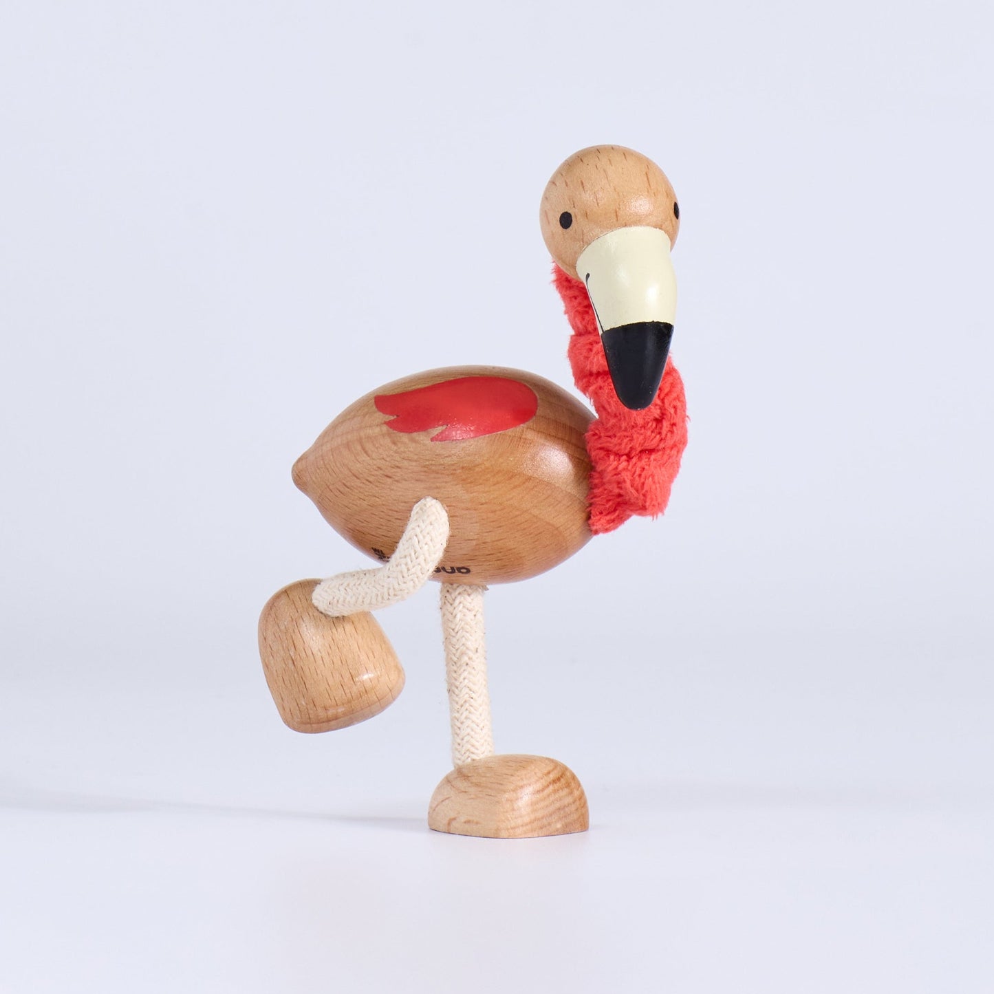 Wooden flamingo figurine on a light gray background