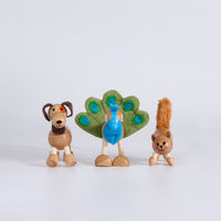 Three wooden animal figurines dog, peacock and cat on a white background