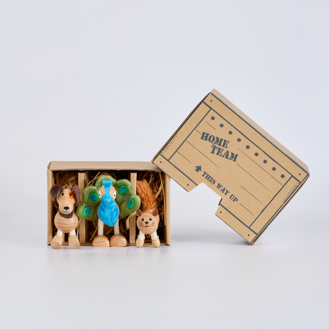 Three small animal figurines in a cardboard box labeled 'Home Team' on a white background