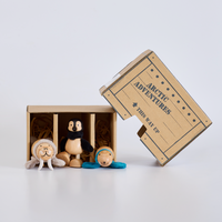 Toy animals in a cardboard box labeled 'Arctic Adventures' on a white background