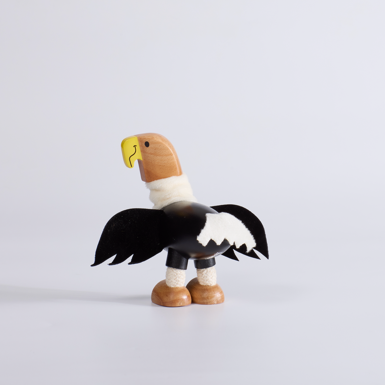 Wooden toy eagle figure on a light gray background