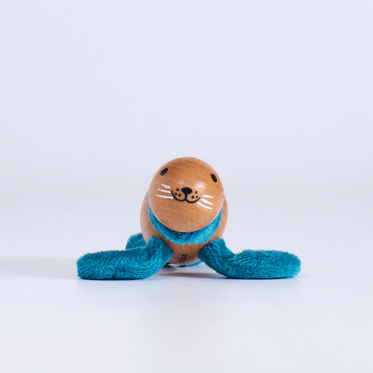 Wooden toy seal with a blue scarf on a white background