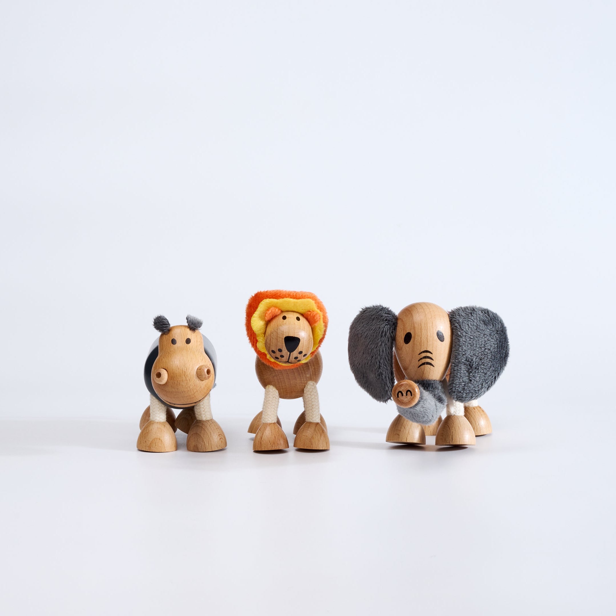 Three wooden animal figurines on a white background
