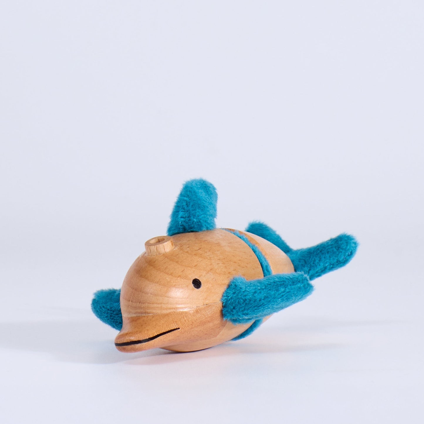 Wooden toy dolphin with blue accents on a white background