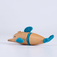 Wooden toy dolphin with plush blue accents on a white background