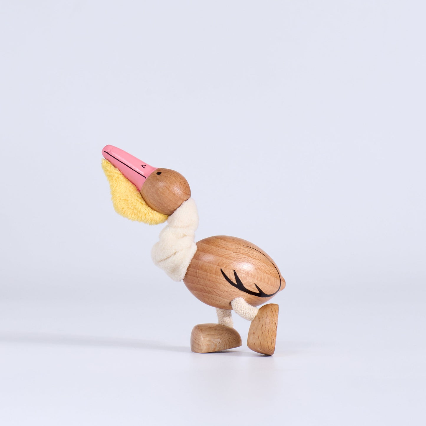 Wooden pelican toy on a light gray background