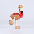 Wooden flamingo figurine on a light gray background