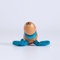 Wooden toy  seal with a blue scarf on a white background