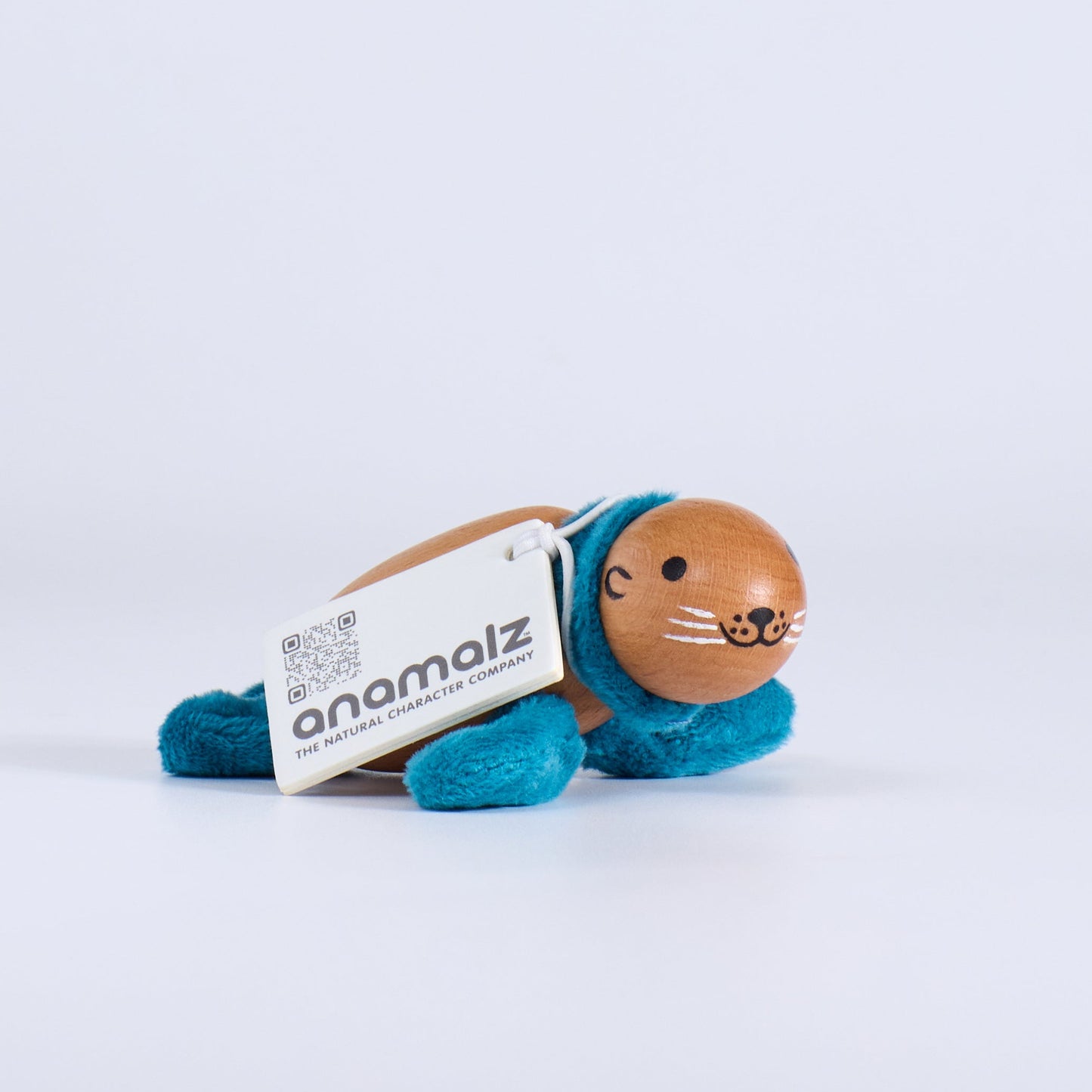 Small plush toy with a white label on a light gray background