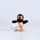 Wooden penguin figurine with black wings and a white card displaying 'anamaiz' on a light gray background