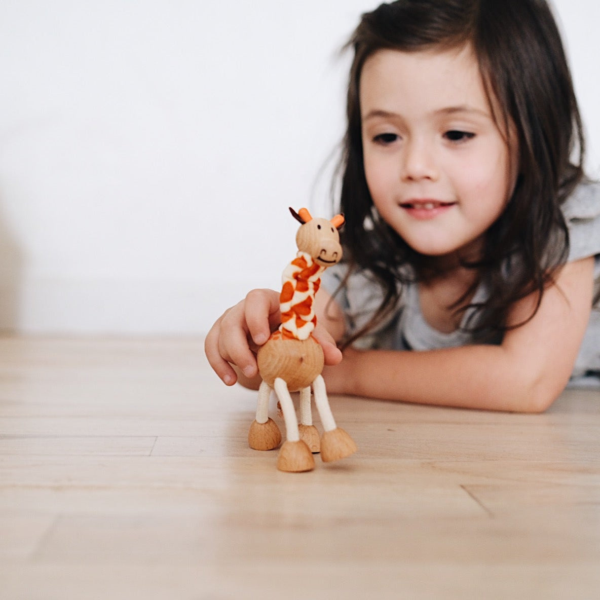 Whimsical eco giraffe toy made from wood and rope, perfect for imaginative play and adventure.