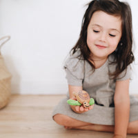 Adorable eco-friendly wooden turtle toy with fabric flippers and a smiling face, perfect for imaginative play and learning.